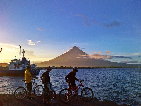 Bikers, the sea, the sky, and Mayon Volcano. :)